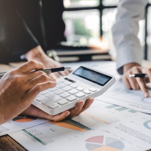 Businesswoman or accountant working Financial investment on calculator, calculate, analyze business and marketing growth on financial document data graph, Accounting, Economic, commercial concept.